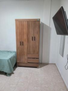 a wooden cabinet in a room with a tv at Hostal viroleño in Zacatecoluca