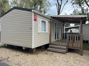 a tiny house with a dog sitting on the porch at rouge gorge in Valras-Plage