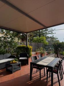 a patio with a table and chairs and an umbrella at Casa Glicine in Sperlonga