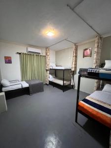 a room with three bunk beds and a table at Sundays Hostel Sigiriya in Sigiriya