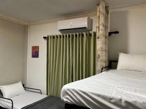 a bedroom with a bed and a green curtain at Sundays Hostel Sigiriya in Sigiriya