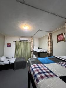 a room with two beds and two tables in it at Sundays Hostel Sigiriya in Sigiriya +10 photos