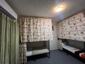 a room with two bunk beds and a curtain at Sundays Hostel Sigiriya in Sigiriya
