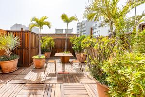 a patio with palm trees and a table and chairs at Hotel Le Djoloff in Dakar
