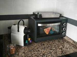 a microwave on a counter with a slice of pizza at El Mirador del Asno in El Bosque