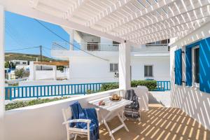 a white pergola on a patio with a table and chairs at Livanios Studios in Adamantas
