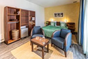 a hotel room with a bed and two chairs and a table at Hotel Le Djoloff in Dakar