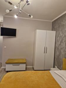 a bedroom with a bed and a white cabinet at Sunny Studio Mamaia Nord in Mamaia Sat/Năvodari