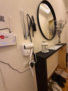 a vanity with a mirror and a hair dryer on a wall at The sweet room in Ganja +46 photos