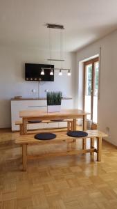 a living room with a wooden table and two benches at Richters Alpen Appartement in Buchenberg