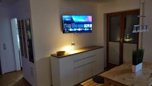 a living room with a flat screen tv on the wall at Richters Alpen Appartement in Buchenberg