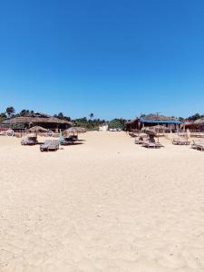 a sandy beach with chairs and umbrellas on it at Flobestian's Seafront Villa in Candolim