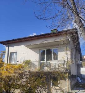 a white house with a balcony on the side of it at Апартамент за гости Вамсон in Velingrad