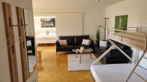 a living room with a couch and a bed and a table at Richters Alpen Appartement in Buchenberg