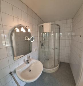 a white bathroom with a sink and a shower at Richters Alpen Appartement in Buchenberg +28 photos