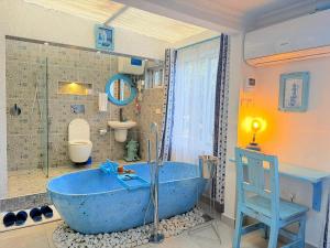 a large blue tub in a bathroom with a toilet at 2 Bedroom en-suite studios by The Prime Escape in Arusha