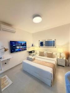 a bedroom with a large bed and a flat screen tv at 2 Bedroom en-suite studios by The Prime Escape in Arusha