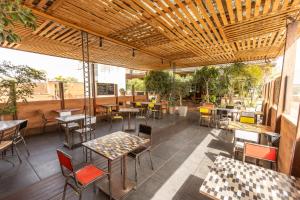 an outdoor patio with tables and chairs and tablesearcher at Hotel Le Djoloff in Dakar +17 photos