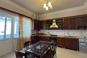 a kitchen with wooden cabinets and a glass table at Sirik hotel in Zvartnots International Airport