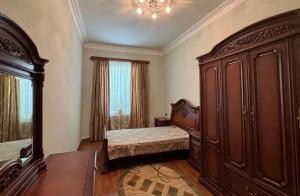 a bedroom with a bed and a large wooden cabinet at Sirik hotel in Zvartnots International Airport
