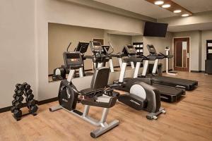 a gym with several treadmills and elliptical machines at Urbana Hotel Conference Center in Urbana
