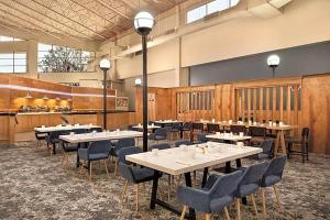 a restaurant with tables and chairs in a room at Urbana Hotel Conference Center in Urbana +8 photos