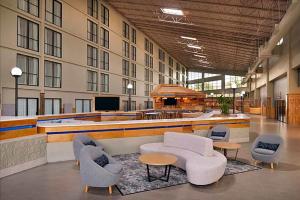 a lobby with couches and chairs in a building at Urbana Hotel Conference Center in Urbana