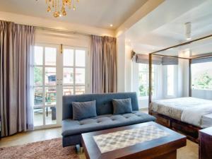 a bedroom with a blue couch and a bed at Hotel Pajaros Blu in Calangute +65 photos