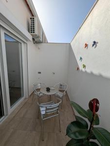 a balcony with a table and chairs on a wall at Casas Albano 2 in Caldas da Rainha
