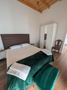 a bedroom with a large bed with green sheets at Casas Albano 2 in Caldas da Rainha