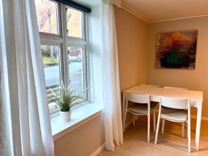 a dining room with a table and a window at Villa Holmen, ground floor apartment in Balestrand