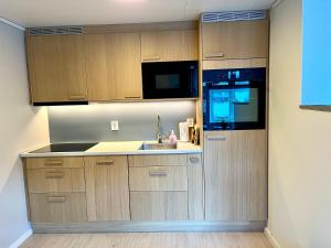 a kitchen with a sink and a microwave at Villa Holmen, ground floor apartment in Balestrand