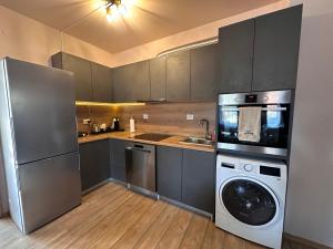 a kitchen with a refrigerator and a washing machine at Alenik Private Apartment -Pamporovo in Pamporovo