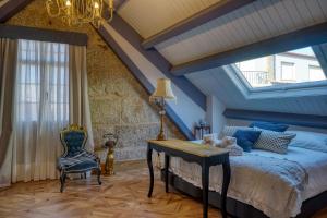 a bedroom with a bed and a table and a chair at Hotel Boutique Cata & Rose - Exclusivo y tranquilo en O Grove in O Grove