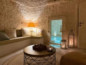 a living room with a table and a window at Trulli Fichi Luxury Trullo with Private Spa and Saltwater Pool in Santa Lucia +102 photos