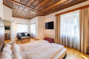 a hotel room with two beds and a couch at Herzogshof - Boutique-Hotel am Dom in Regensburg