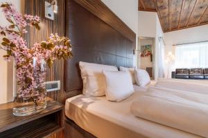 a bedroom with a bed and a vase of flowers at Herzogshof - Boutique-Hotel am Dom in Regensburg +97 photos