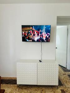 a flat screen tv on a white wall at Papagayo in Bayahibe