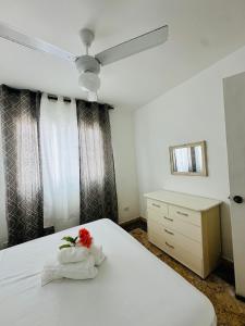 a bedroom with a white bed with a flower on it at Papagayo in Bayahibe