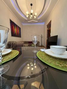 a dining room with a glass table with plates and glasses at The sweet room in Ganja