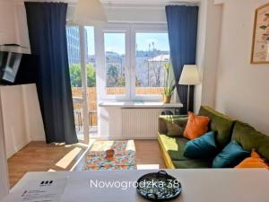 ein Wohnzimmer mit Sofa und großem Fenster in der Unterkunft Apple Inn in Warschau