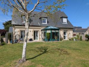 a house with a tree in the yard at Plage du Pont - Chambres d'Hôtes in Saint Malo