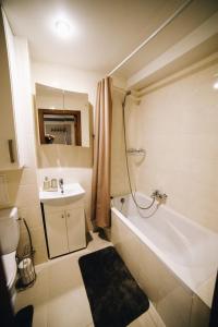 a bathroom with a tub and a sink and a toilet at MD Apartment in Rēzekne