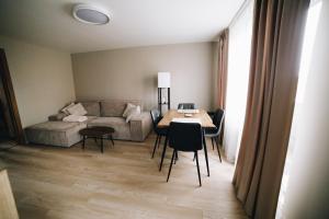 a living room with a table and a couch at MD Apartment in Rēzekne +14 photos