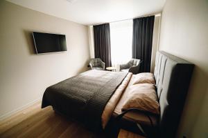 a bedroom with a bed and a tv on the wall at MD Apartment in Rēzekne