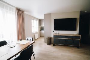 a living room with a flat screen tv on a wall at MD Apartment in Rēzekne