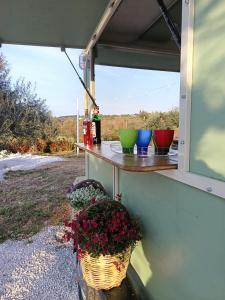 a porch with a table with colorful bowls on it at Trulli Fichi Luxury Trullo with Private Spa and Saltwater Pool in Santa Lucia