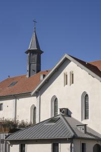 a white church with a steeple on top of it at La Chapelle in Annecy