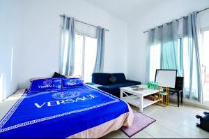 a bedroom with a blue bed and a couch at Studio - Private - Abu Dhabi in Abu Dhabi
