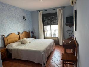 a bedroom with a bed and a window at La Garzona in Losar de la Vera